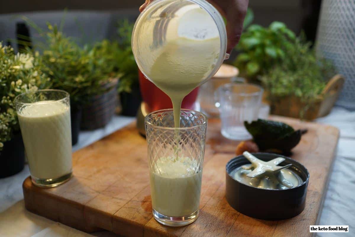 Pouring avocado coconut smoothie into a glass