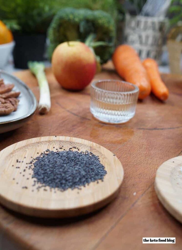A mound pf poppy seeds on a wooden dish