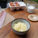 Ingredients for Bacon Egg and Cheese Cups on a wooden chopping board