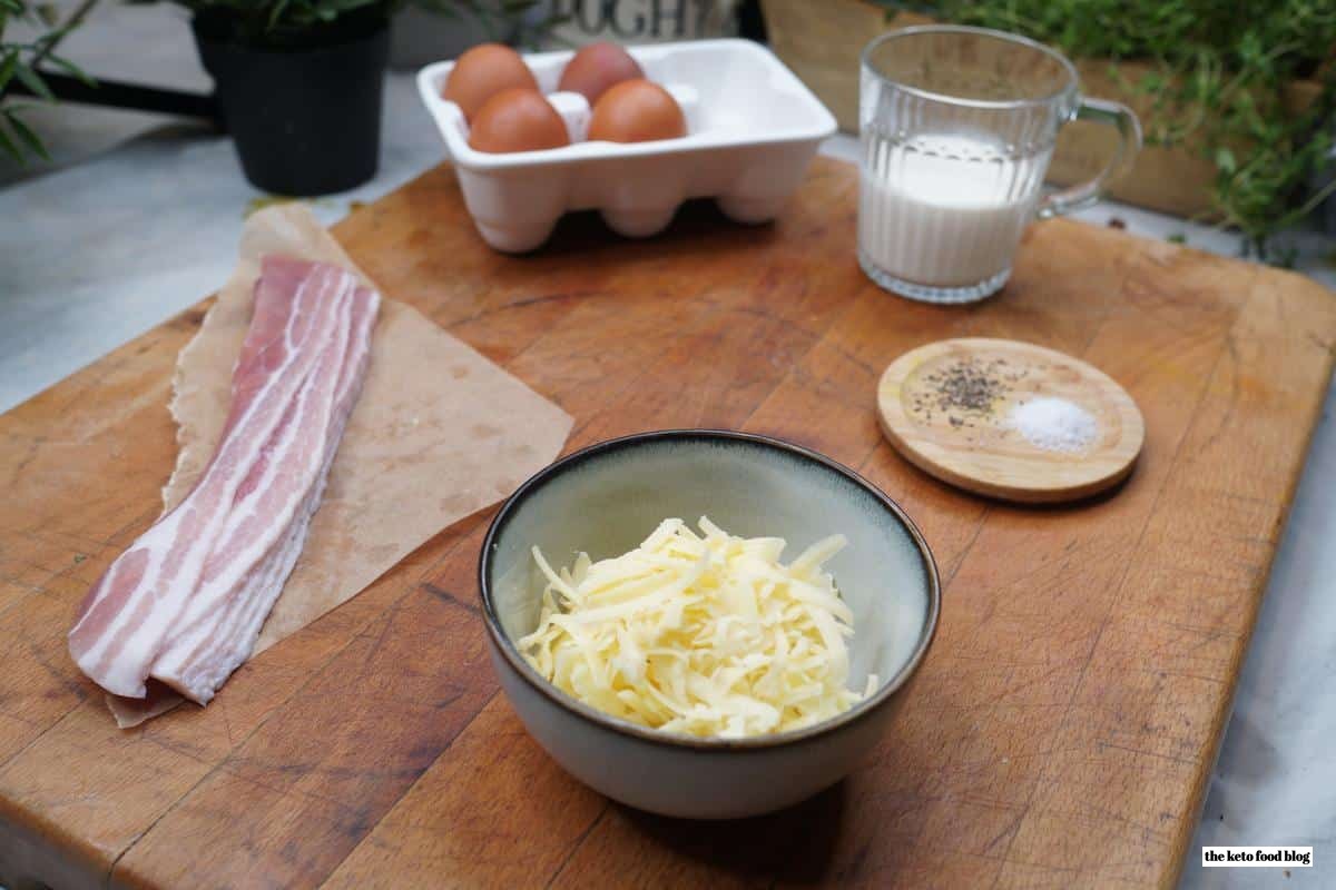 Ingredients for Bacon Egg and Cheese Cups on a wooden chopping board