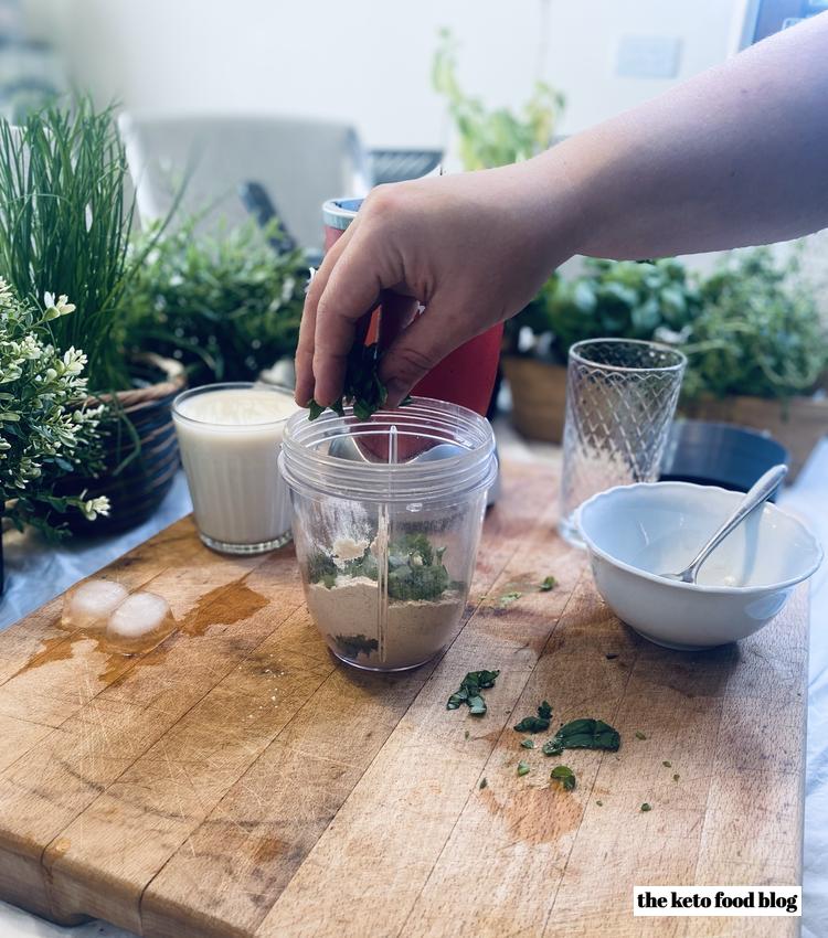 Sprinkling chopped fresh basil into a nutribullet cup