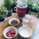 Ingredients for Chocolate Covered Strawberry Smoothie on wooden chopping board