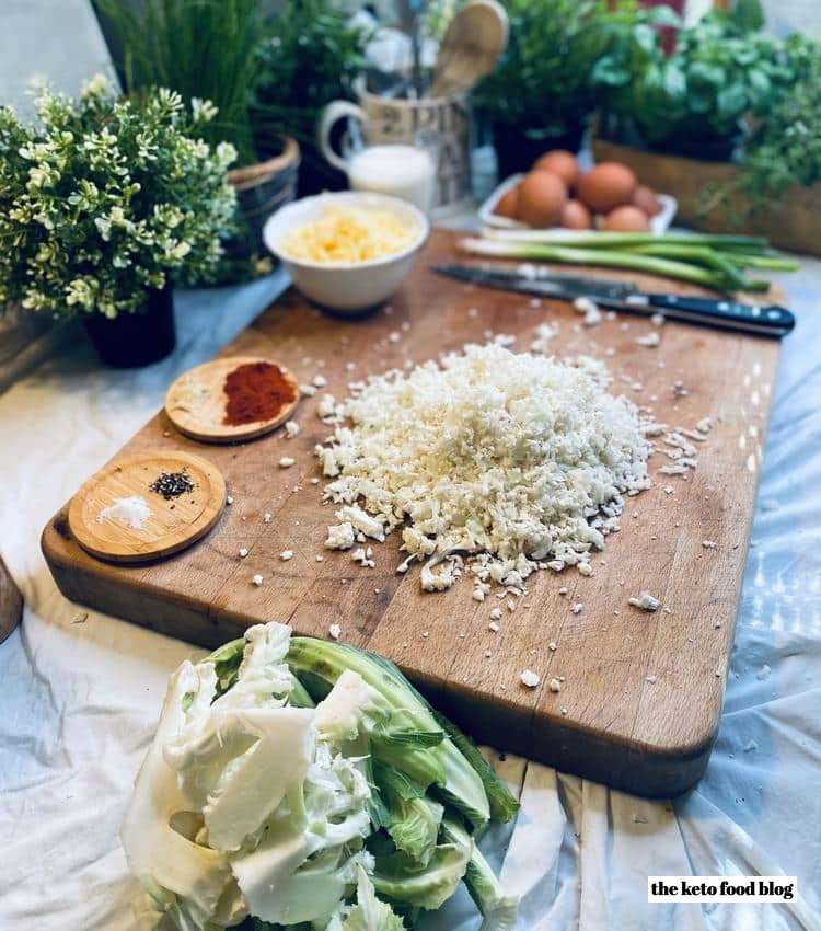 Grated cauliflower on a wooden chopping board