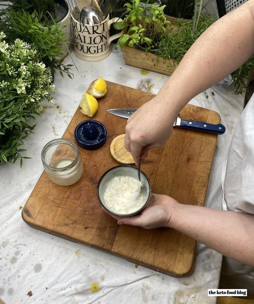 Mixing together mayonnaise, lemon juice and pepper