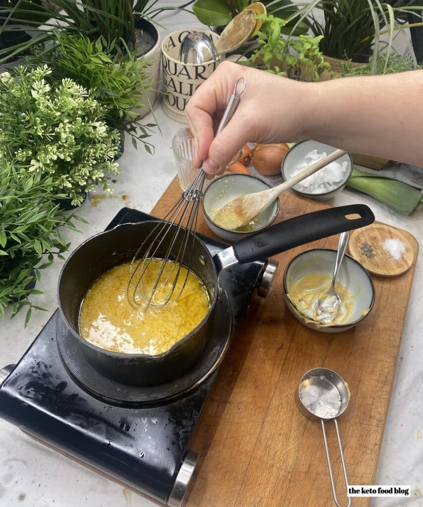 Whisking a sauce made with ghee, coconut butter, mustard and chicken stock