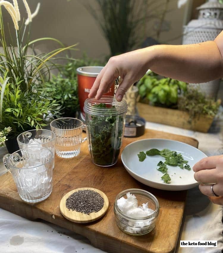 Packing a nutribullet full of kale and spinach