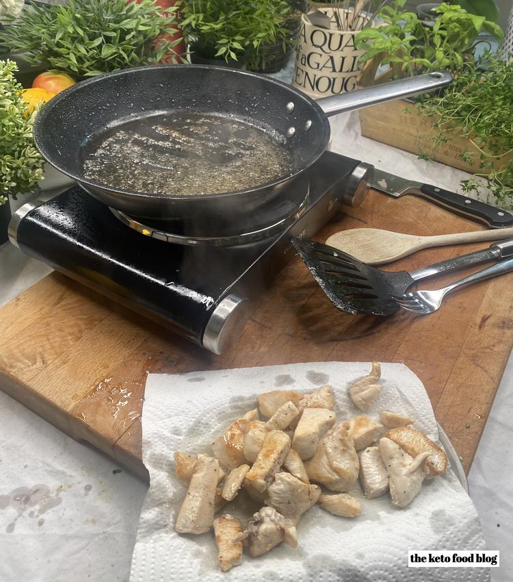 Cooked chicken resting after being fried in a skillet