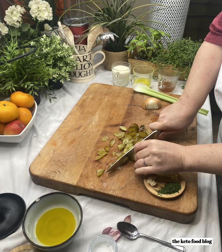 Chopping dill pickles on a wooden chopping board