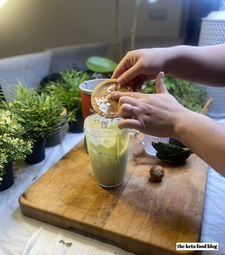 Adding coconut flakes to a smoothie