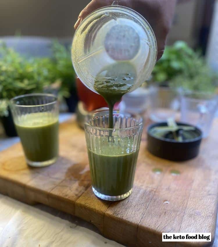 Pouring a green smoothie into a glass