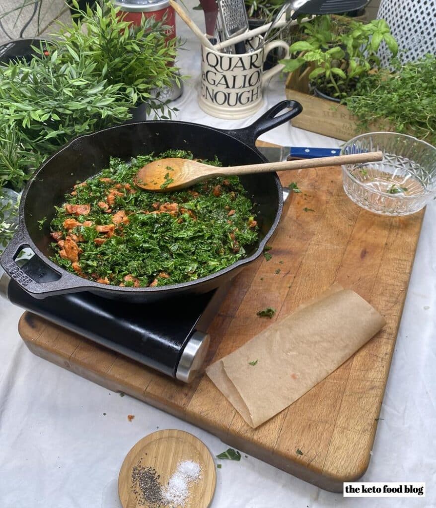 Cooking spanish chorizo with chopped kale in a skillet