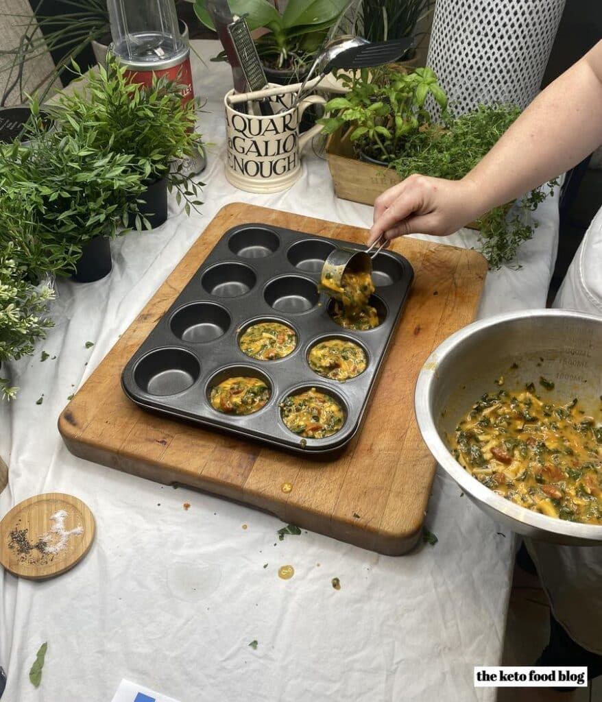 Spooning egg mixture into a 12 hole muffin tin 