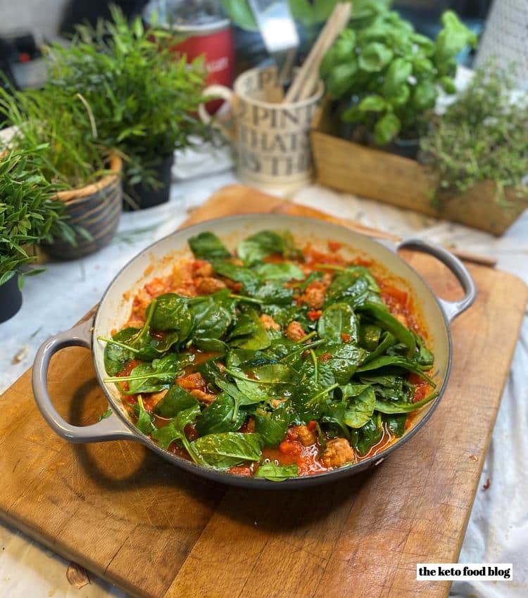 Adding spinach to a bubbling Italian Sausage Keto Soup