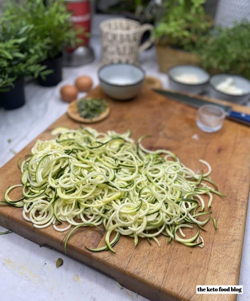 a pile of spiralized zucchini on a chopping board