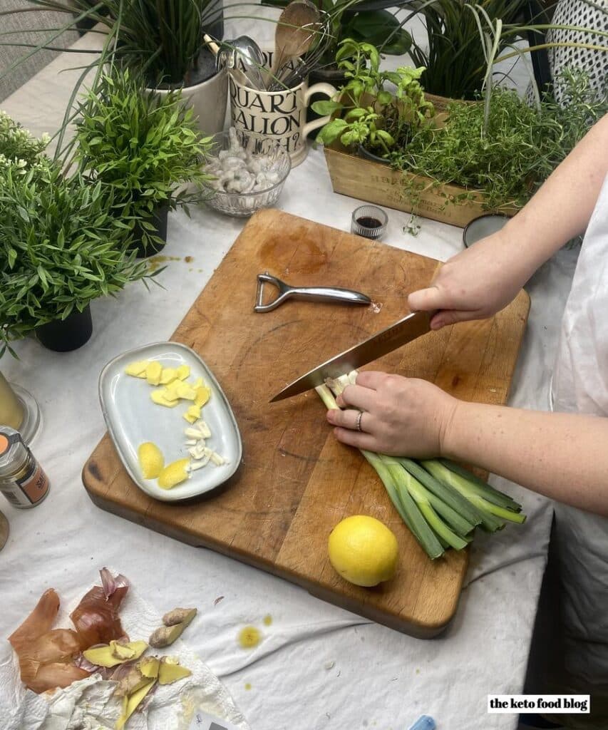 Chopping a small bunch of spring onions on a wooden board