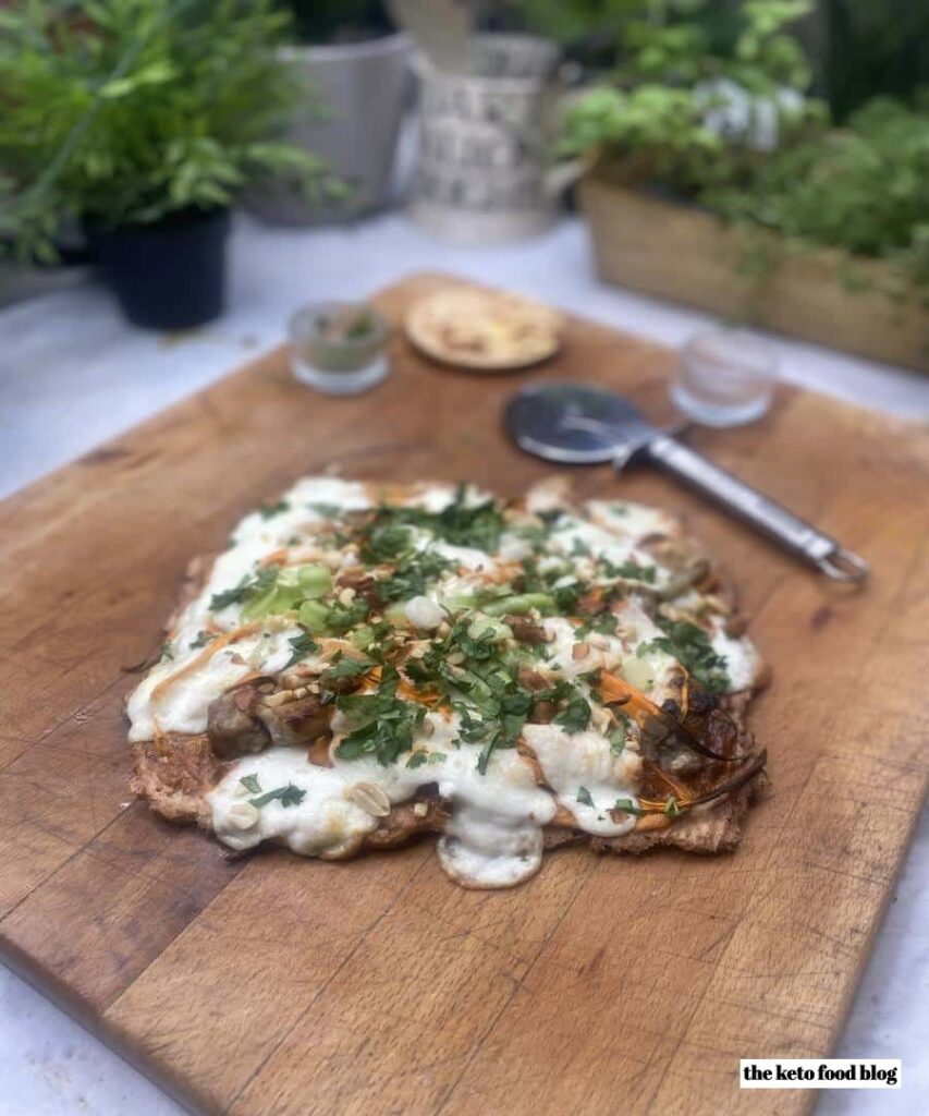 Keto Thigh Chicken Flatbread Pizza on wooden chopping board