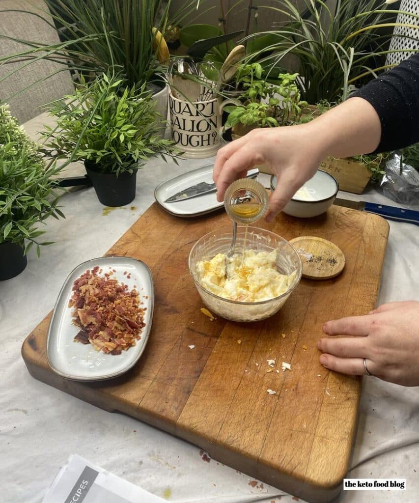 Pouring bacon fat into a bowl of egg and mayonnaise