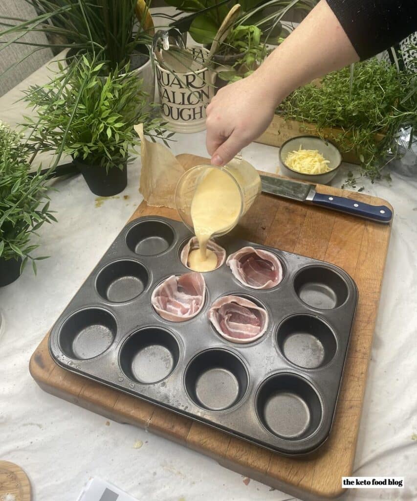 Pouring egg scramble mixture into bacon cups sitting in a muffin tin