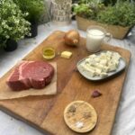 Ingredients for Keto Steak with Blue Cheese on a wooden chopping board