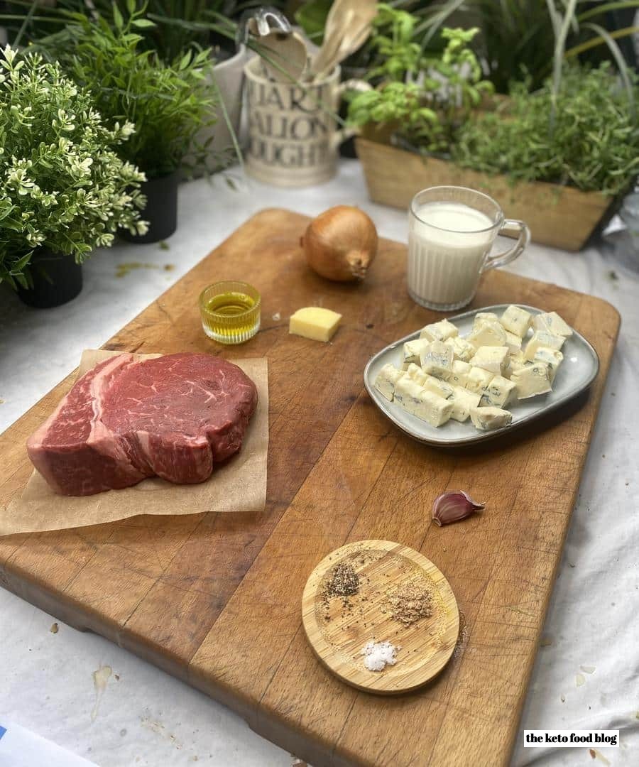 Ingredients for Keto Steak with Blue Cheese on a wooden chopping board