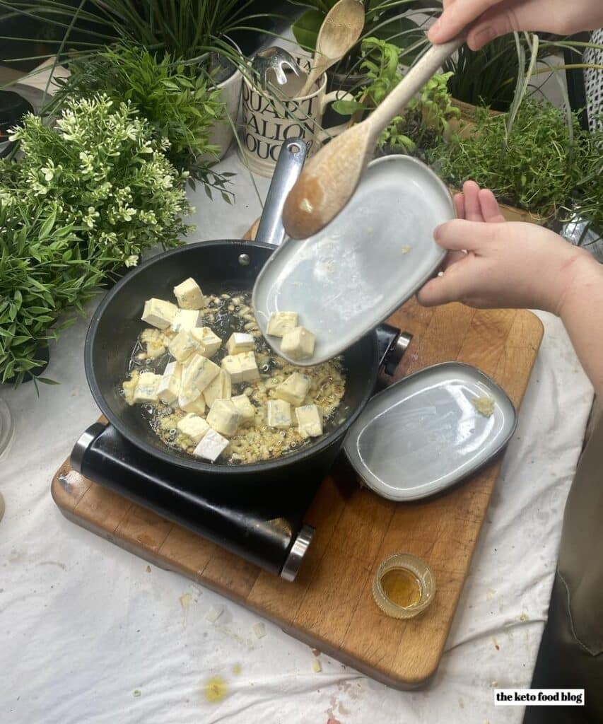 Sliding cubes of blue cheese into the frying pan to make a steak sauce