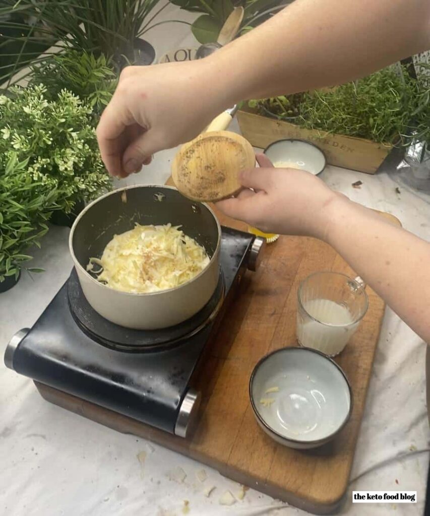 Sprinkling nutmeg into a cheese sauce