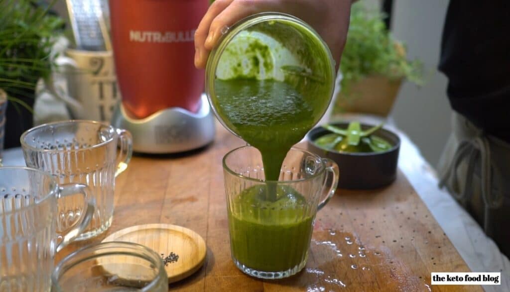 Pouring lean green smoothie into a glass from nutribullet cup