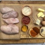 Ingredients presented on a wooden chopping board with copper containers