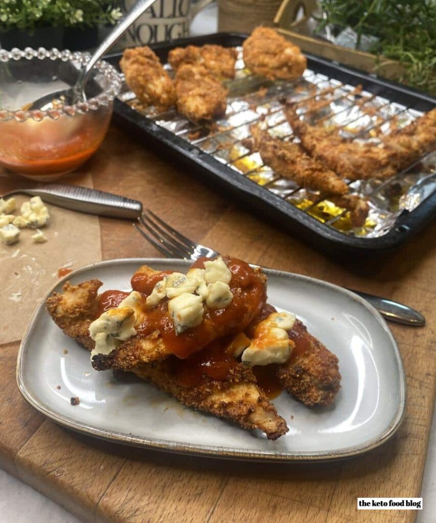 Buffalo Chicken Strips, topped with blue cheese and a spicy buttery sauce